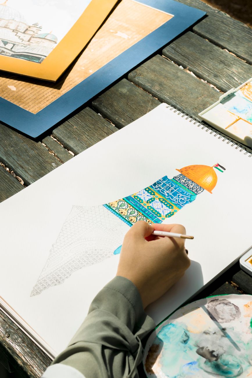 man drawing a tower on paper