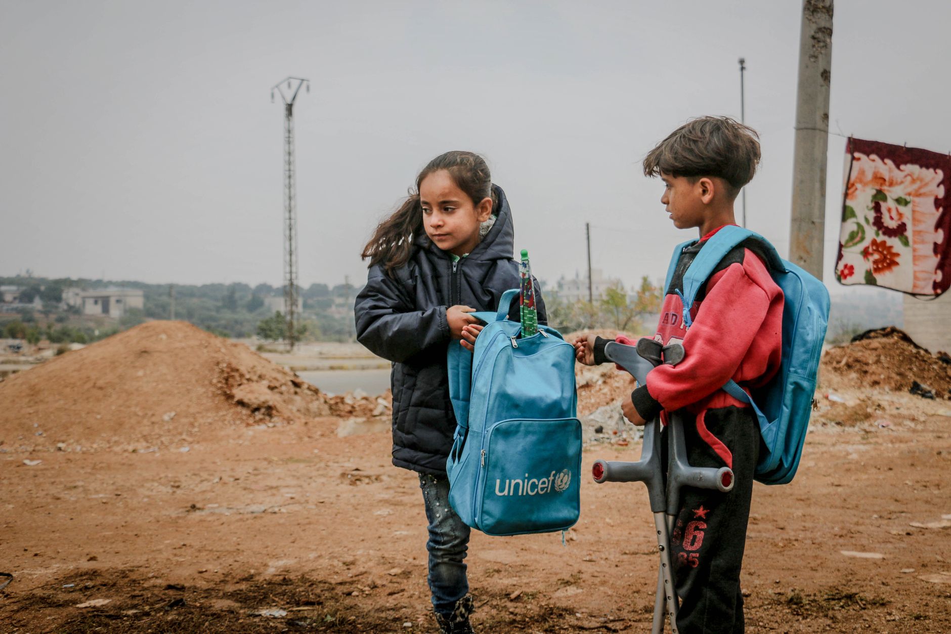 injured ethnic boy and girl with backpacks