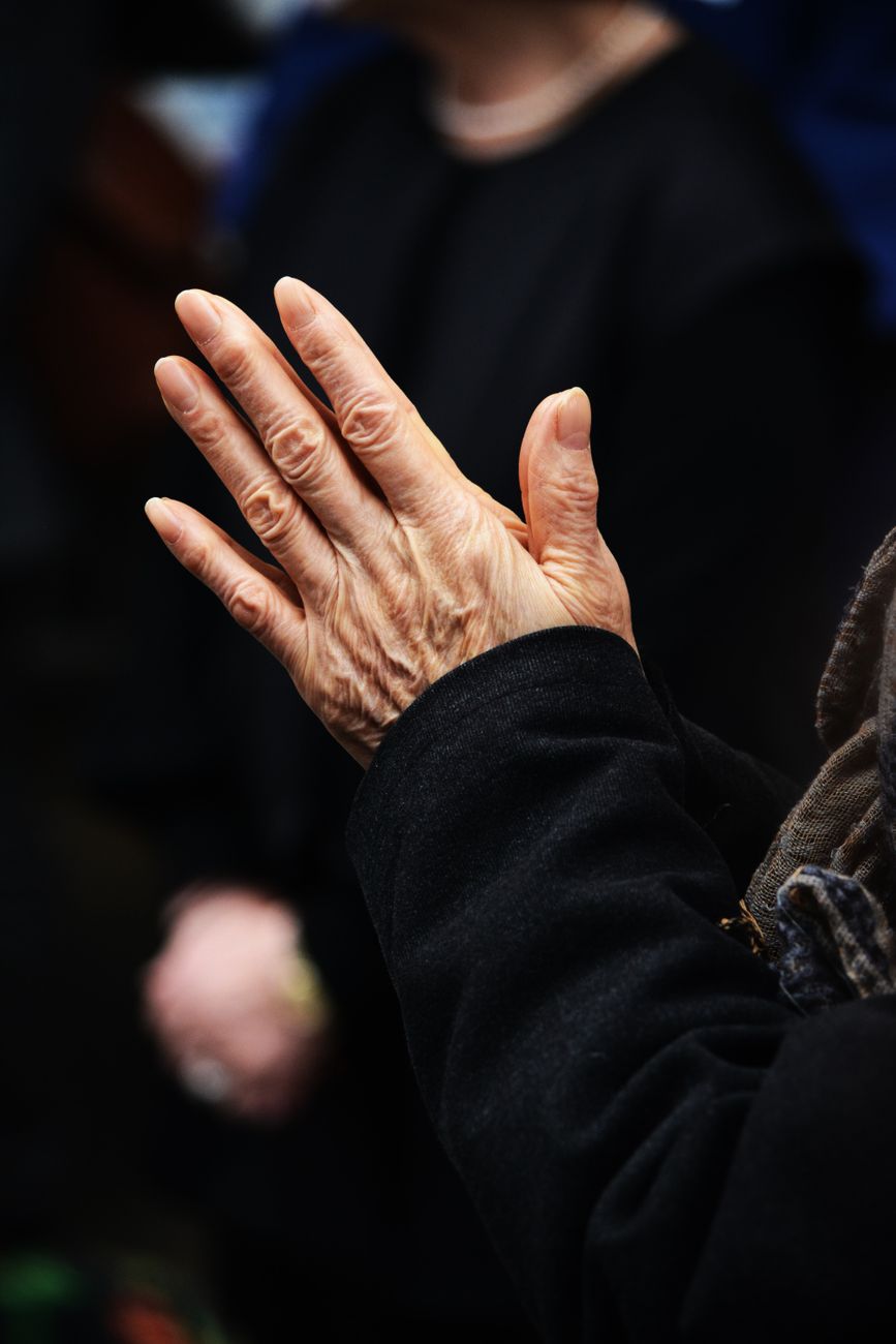 elderly hands in prayerful gesture outdoors
